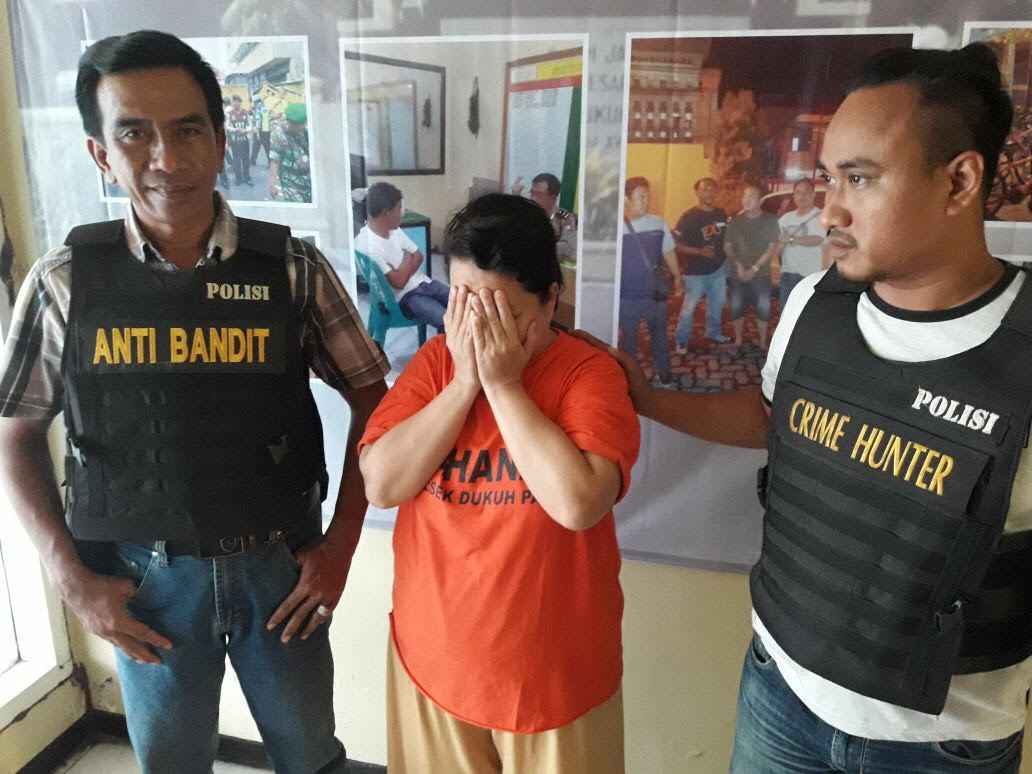 Wiwik (tengah)  diamankan di Mapolsek Dukuh Pakis Surabaya. 