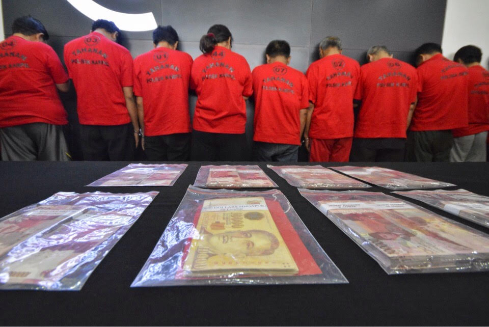 Barang bukti uang palsu dan tersangka saat dibeber di Mapolrestabes Surabaya. 
