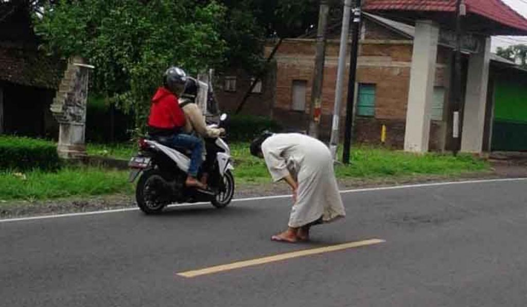 Capture video seorang pria salat di tengah jalan