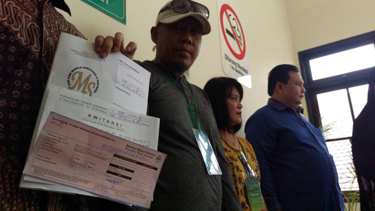 Korban Sipoa menunjukkan bukti gugatan yang didaftarkan ke Pengadilan Negeri Surabaya. 