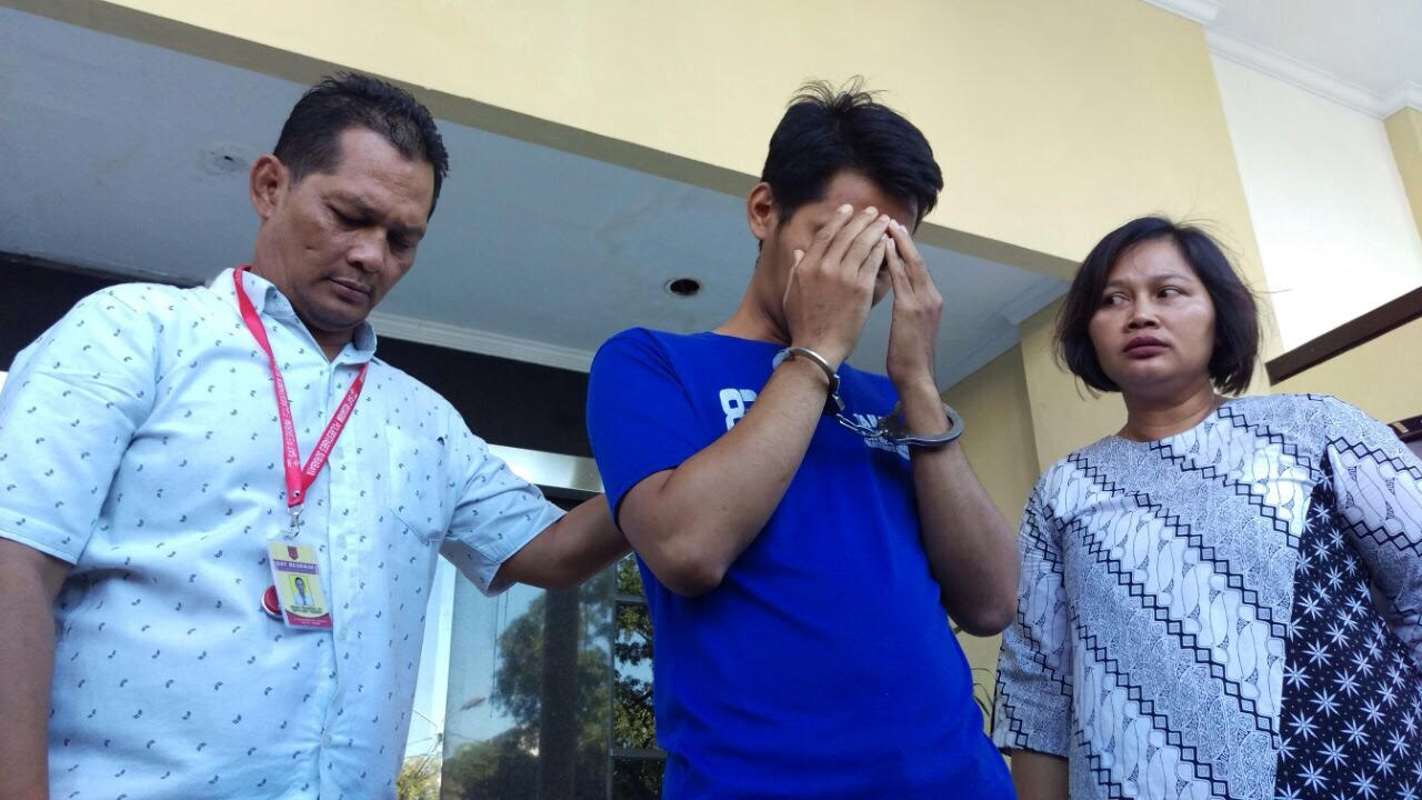 Tersangka Kamiludin (menutup wajah) saat diinterogasi AKP Ruth Yeni