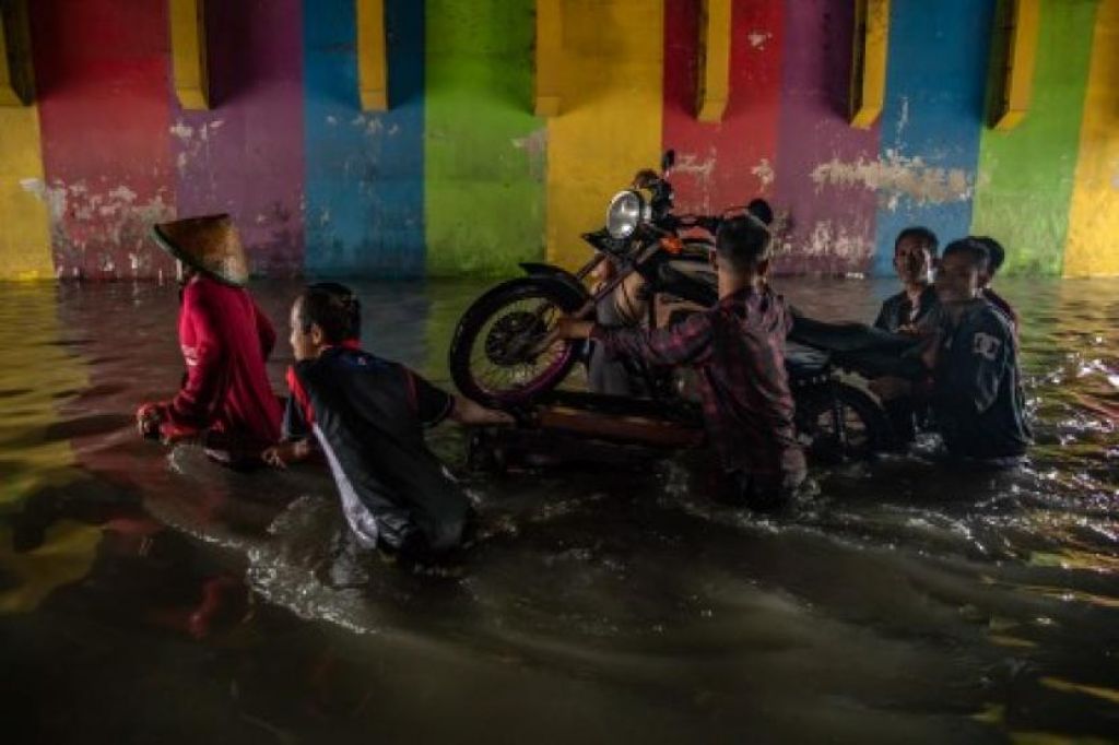 Warga angkut sepeda motor di Jalan Raya Arteri Soekarno-Hatta, Semarang (Foto: ANTARA FOTO/Aji Styawan via Republika)
